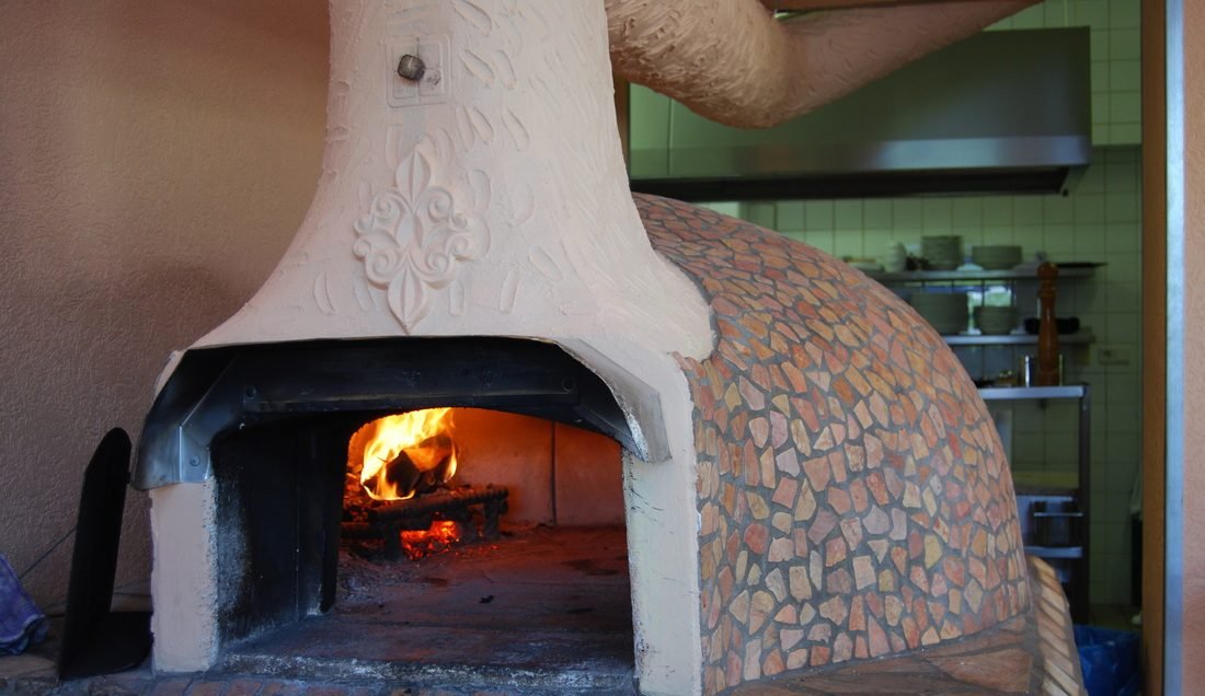 Der Steinofen mit brennendem Feuer im Ristorante Perla